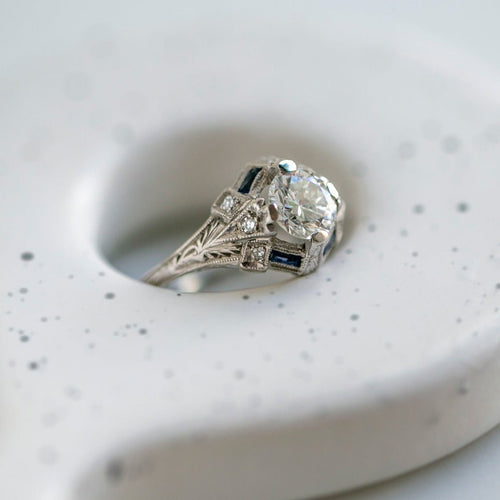 A Dazzling Art Deco Era Platinum, 1ct Round Brilliant Cut Diamond and Sapphire Engagement Ring