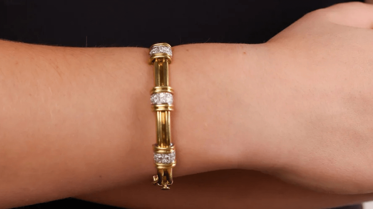 Bold vintage gold bracelet with fluted links and diamond-accented caps, shown on wrist against a dark background for contrast and eleganc