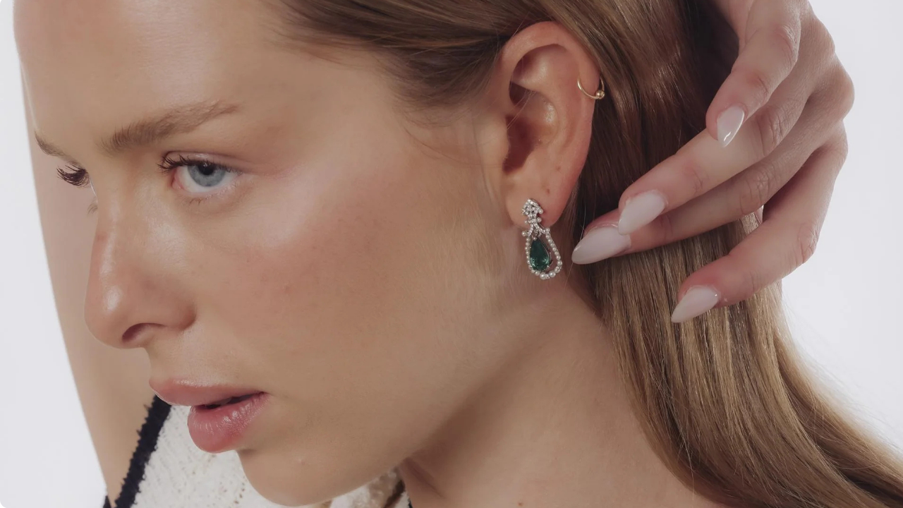Side profile of model wearing mid-century emerald, diamond, and pearl earrings