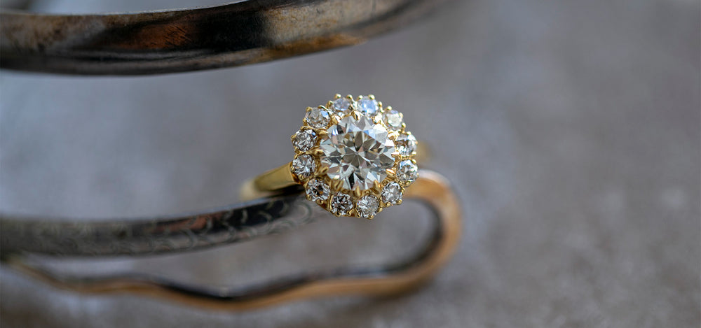 victorian era diamond cluster engagement ring | hickory hills at trumpet & horn yellow gold diamond halo engagement ring with old european cut diamond center and halo of twelve round diamonds in an 18k yellow gold mounting