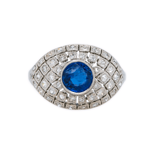 Luxumberg is an Art Deco late Belle Epoch era bombe style platinum and diamond ring featuring a .97ct Burmese sapphire, circa 1926