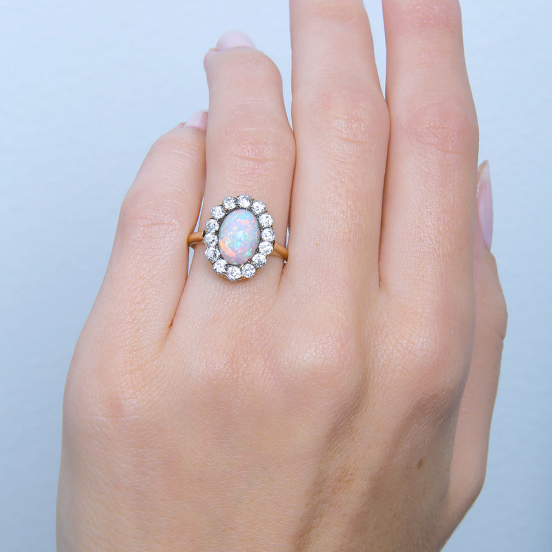 Seagrove | A beautiful and authentic Victorian era oval opal and diamond halo ring in 14k rose gold