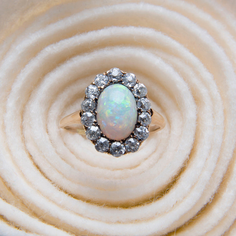 Seagrove | A beautiful and authentic Victorian era oval opal and diamond halo ring in 14k rose gold