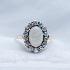 Seagrove | A beautiful and authentic Victorian era oval opal and diamond halo ring in 14k rose gold